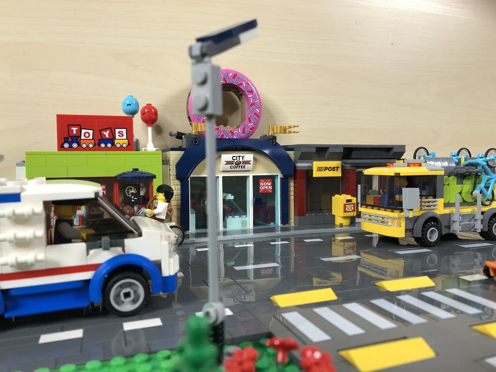 T-Kreuzung mit LEGO City-Gebäuden und Fahrzeugen