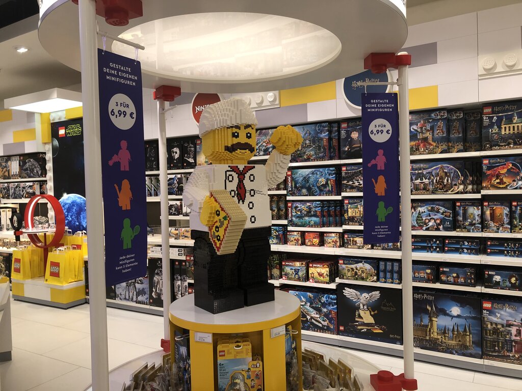 Riesige LEGO Minifigur aus LEGO Steinen bei der Verkaufsfläche für Minifiguren