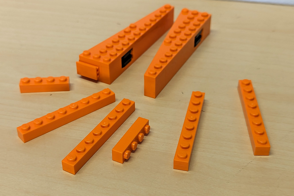 Neben den üblichen Kleinteilen bleiben diese orangenen Elemente übrig. Sie werden beim Zusammenbau nur zeitweilig zur Stabilität benötigt.