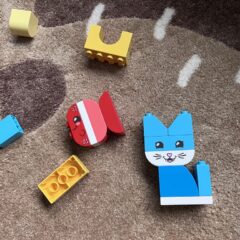 Zusammengebaute Duplo-Tiere auf dem Boden liegend: roter Fisch und blaue Katze